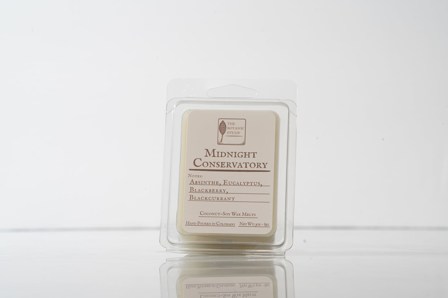 Wax melt container labeled 'Midnight Conservatory' on a white background