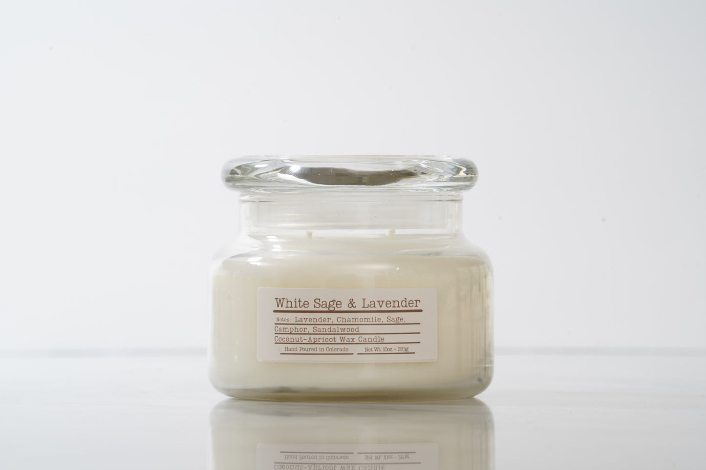 Jar candle labeled 'White Sage & Lavender' on a white background