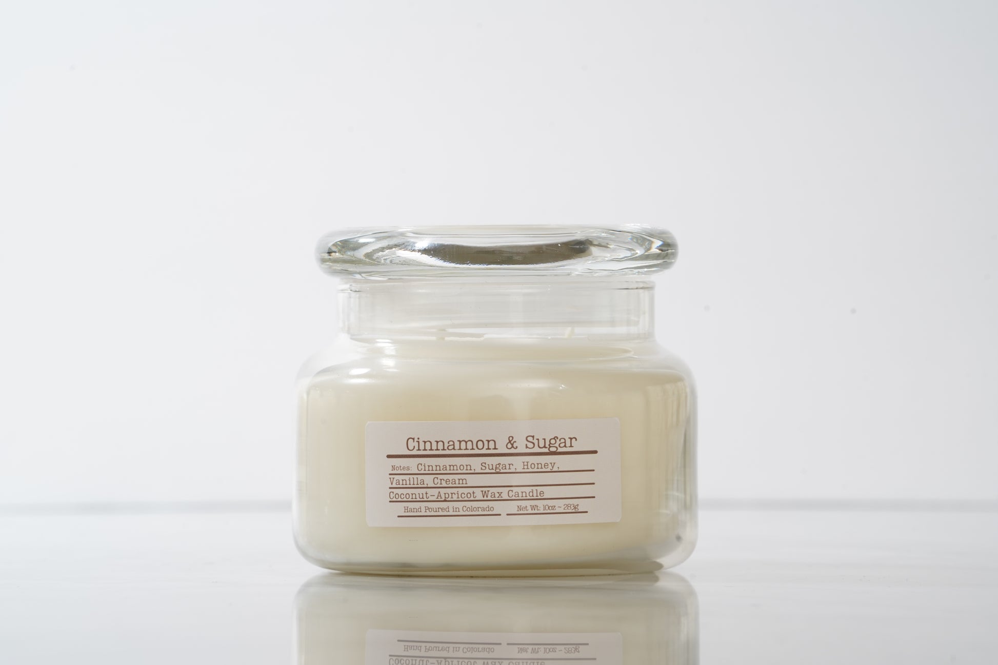 Jar candle labeled 'Cinnamon & Sugar' on a white background