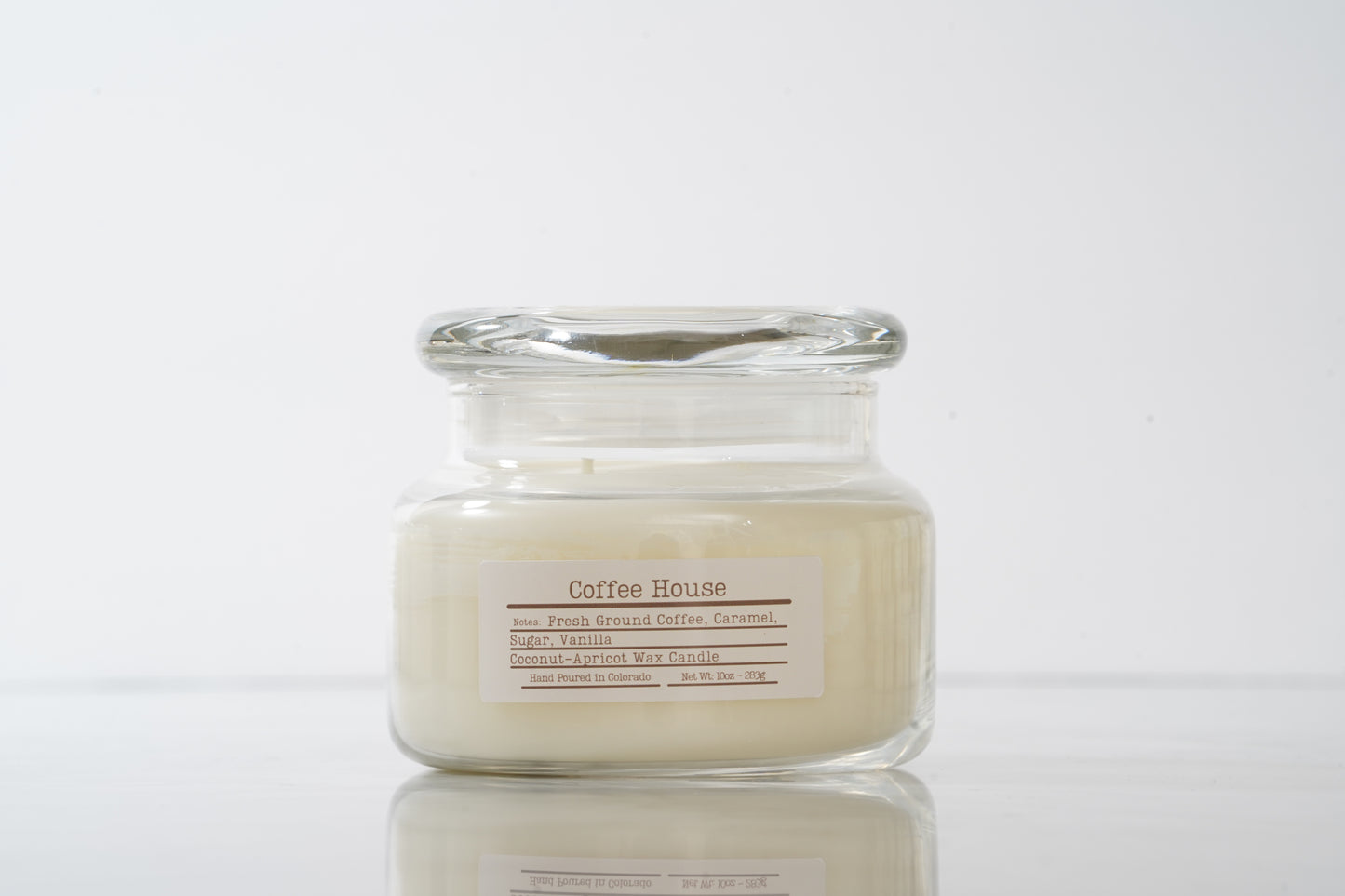 Glass jar candle labeled 'Coffee House' on a light gray background