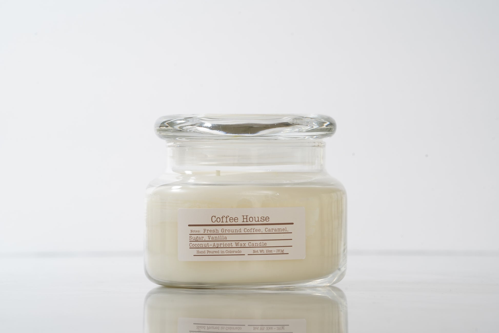Glass jar candle labeled 'Coffee House' on a light gray background