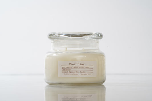 Jar candle labeled 'Fresh Linen' on a white background