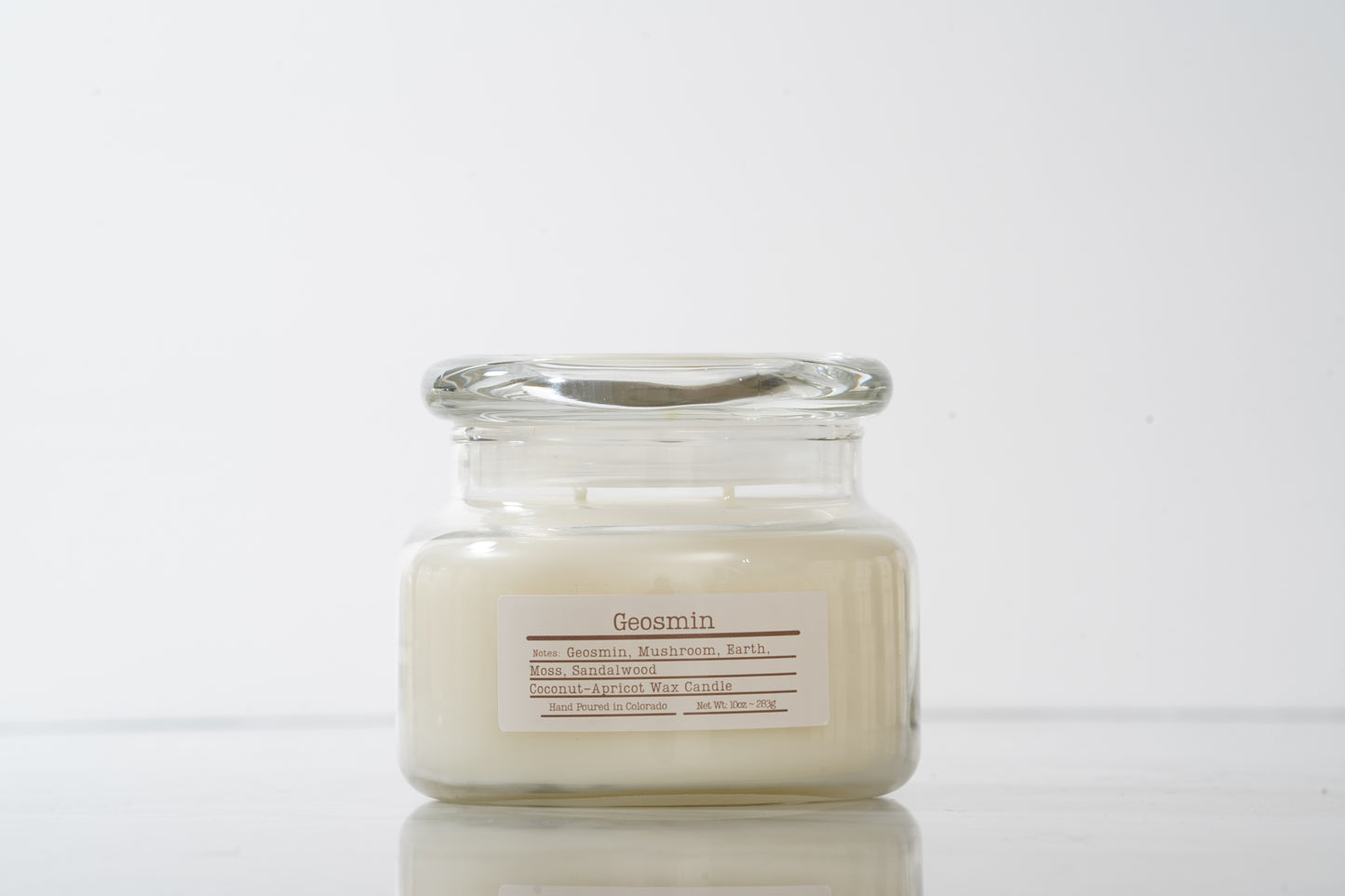 Glass jar scented candle labeled Geosmin