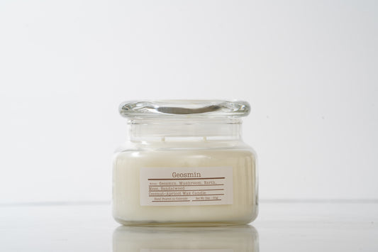 Glass jar scented candle labeled Geosmin